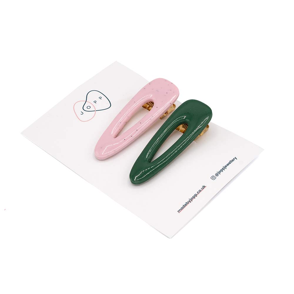Green and pink polymer clay hair clips photographed on white backing card with Jopp branding. White background.