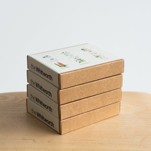Photograph of 4 brown and cream boxes with Whitworth Seeds. Photographed on a brown table against a white background.