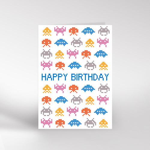 Birthday card with pixelated space invaders design and 'Happy Birthday' text on a white background.