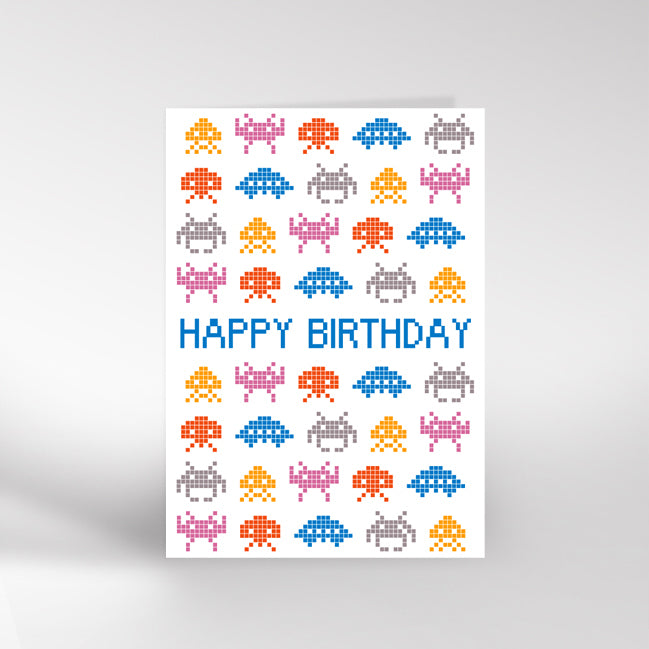 Birthday card with pixelated space invaders design and 'Happy Birthday' text on a white background.