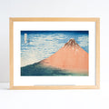 Framed artwork of a mountain landscape with a wooden frame.
