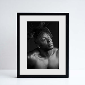 Black framed print containing photographic portrait by Ajamu X