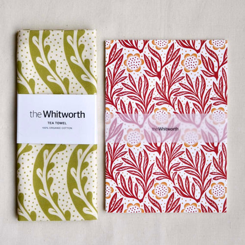 Two patterned tea towel and notebook with 'the Whitworth' branding on a light gray background.