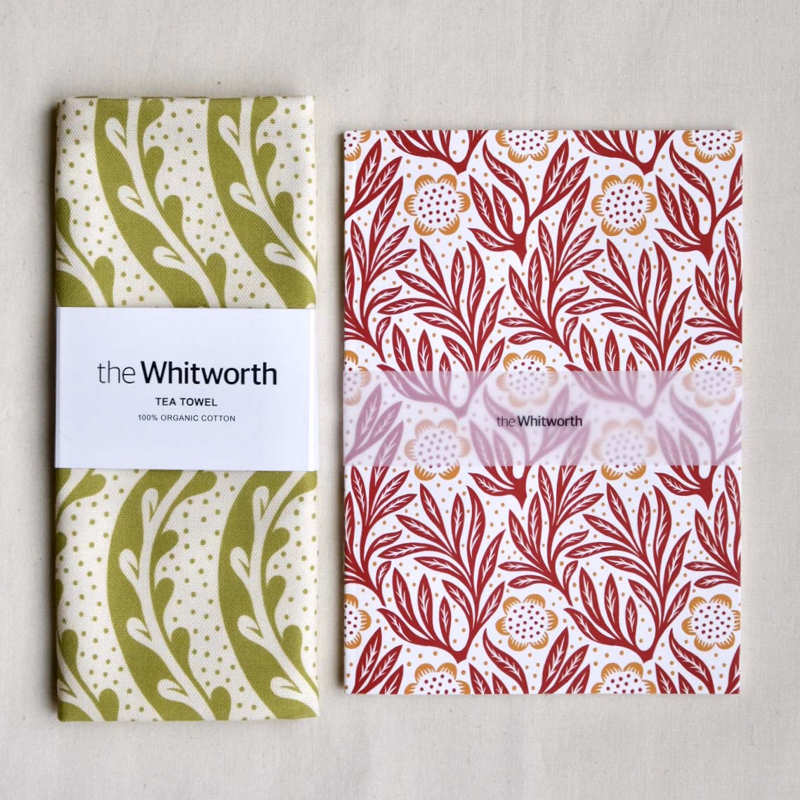 Two patterned tea towel and notebook with 'the Whitworth' branding on a light gray background.