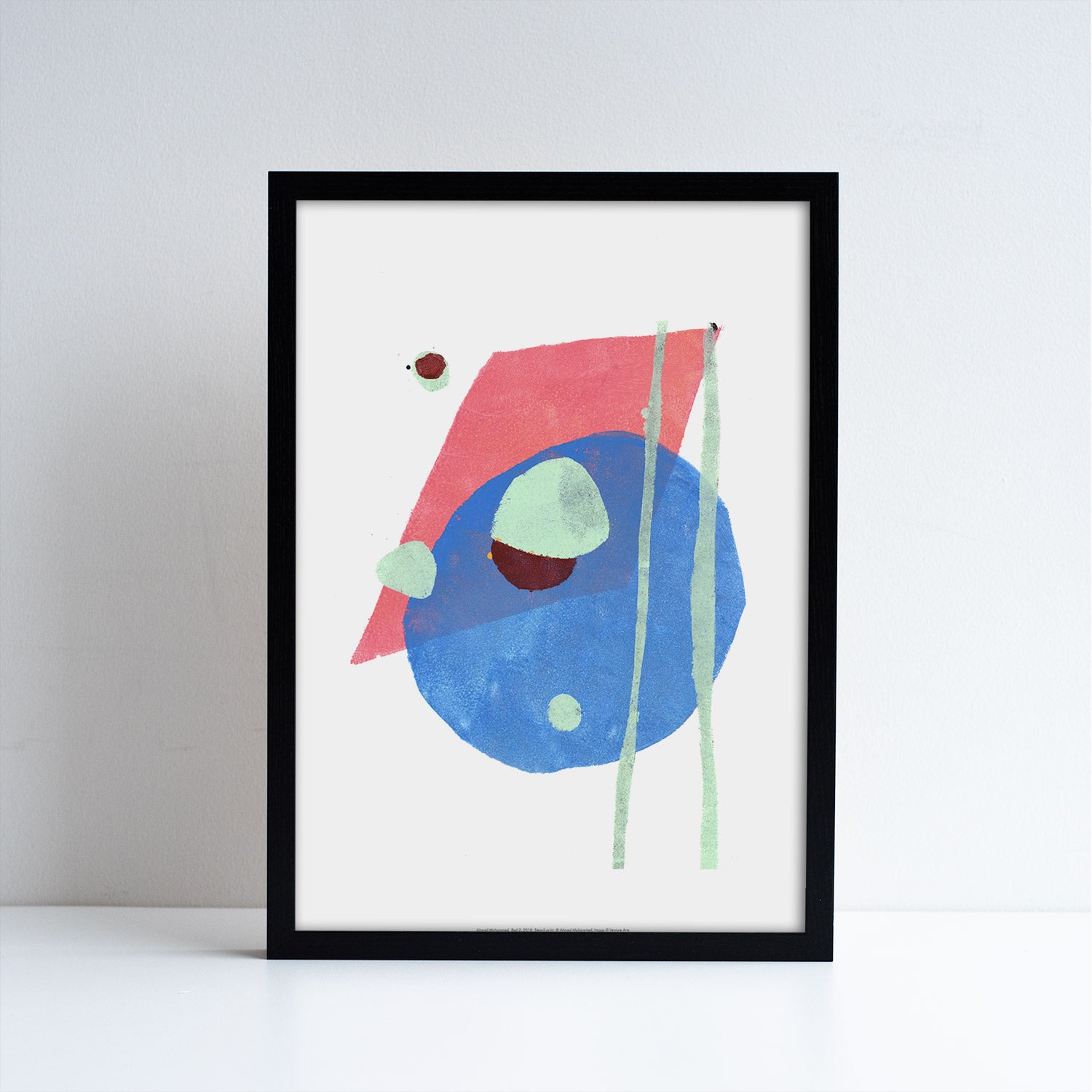 Reproduction of an abstract artwork by Ahmed Mohammed, abstract shapes in blue, green and pink. Placed in a black frame.