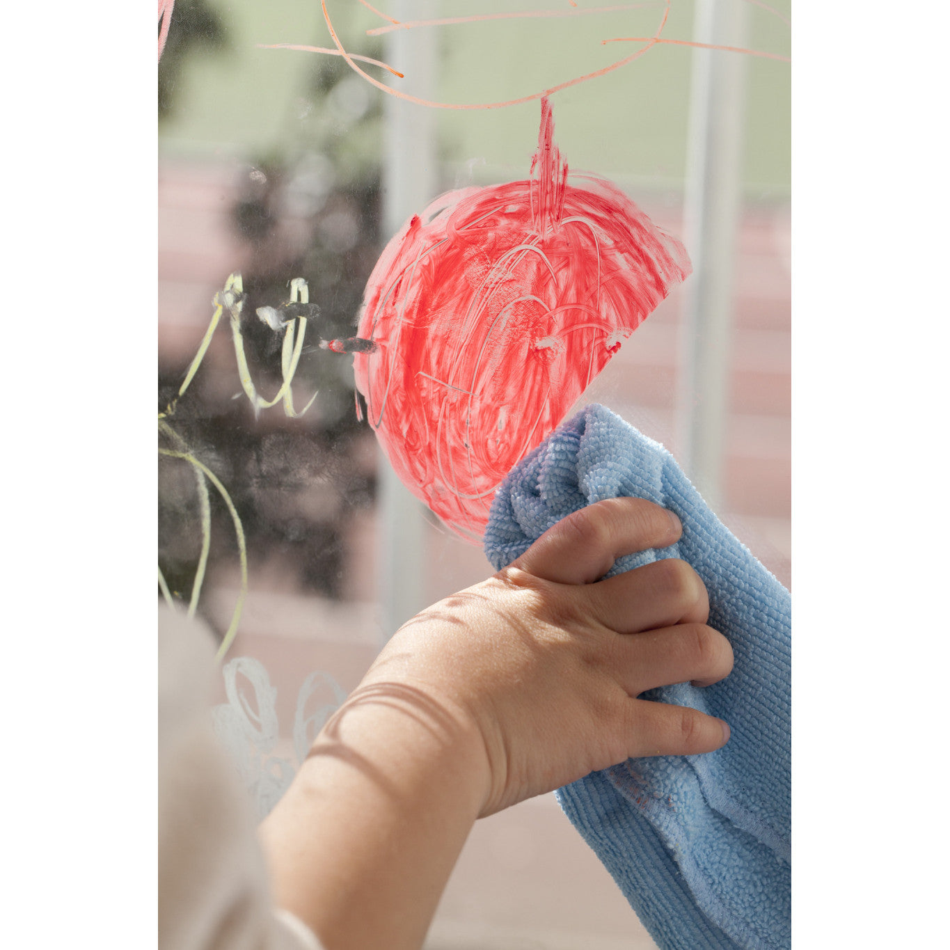 A child using wax crayons on a window