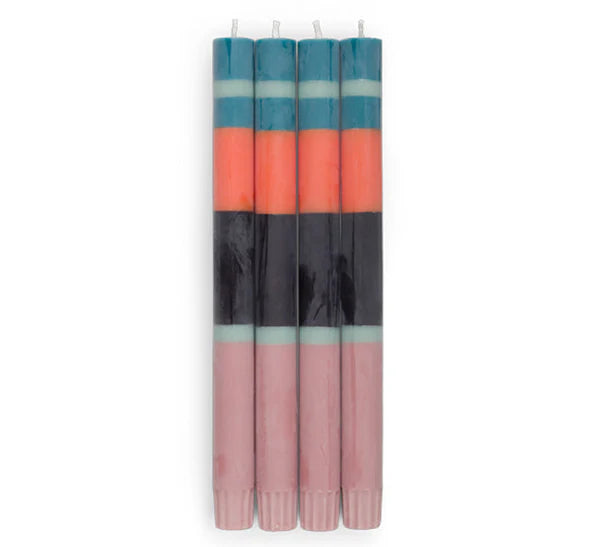 Set of four striped candles with pink, orange, and blue bands on a white background