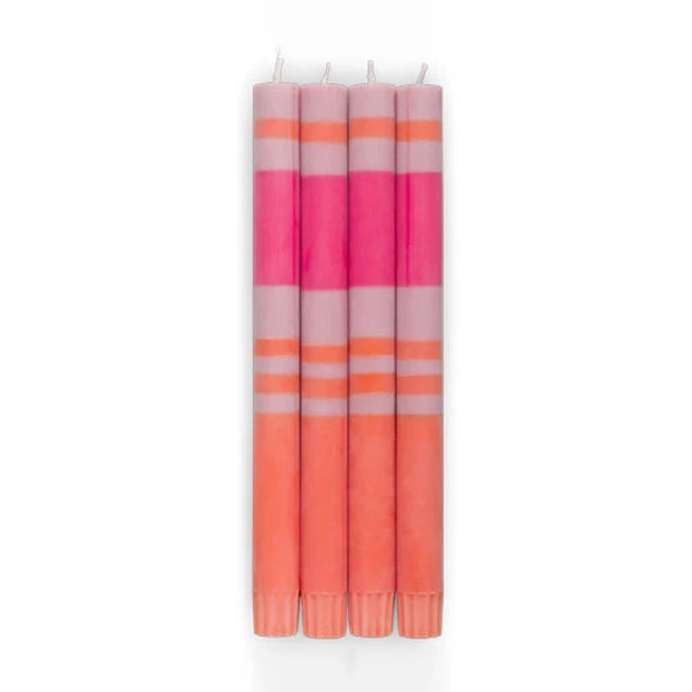 A set of four pink and orange striped taper candles.