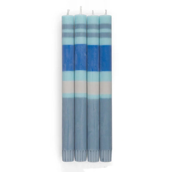 A set of four blue and grey striped taper candles.