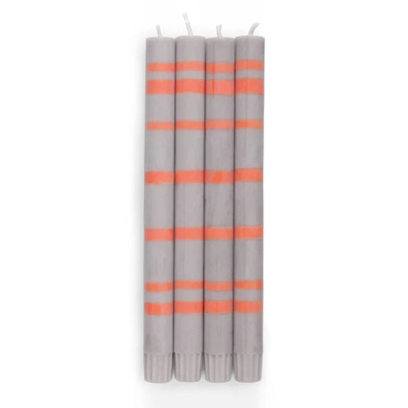 A set of four purple and orange striped taper candles.