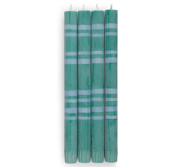 Set of four green candles with white stripes on a white background
