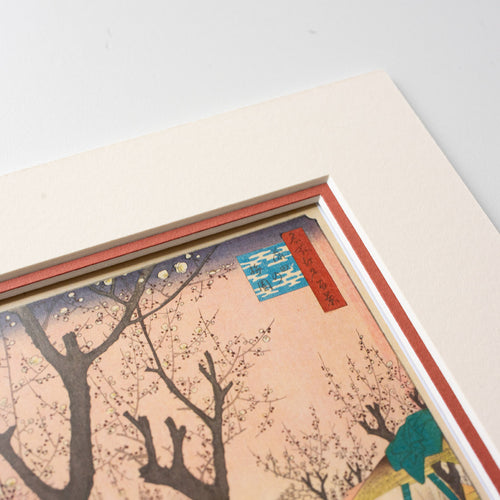 Detail of corner of mounted artwork of a cherry blossom tree scene on a light grey background