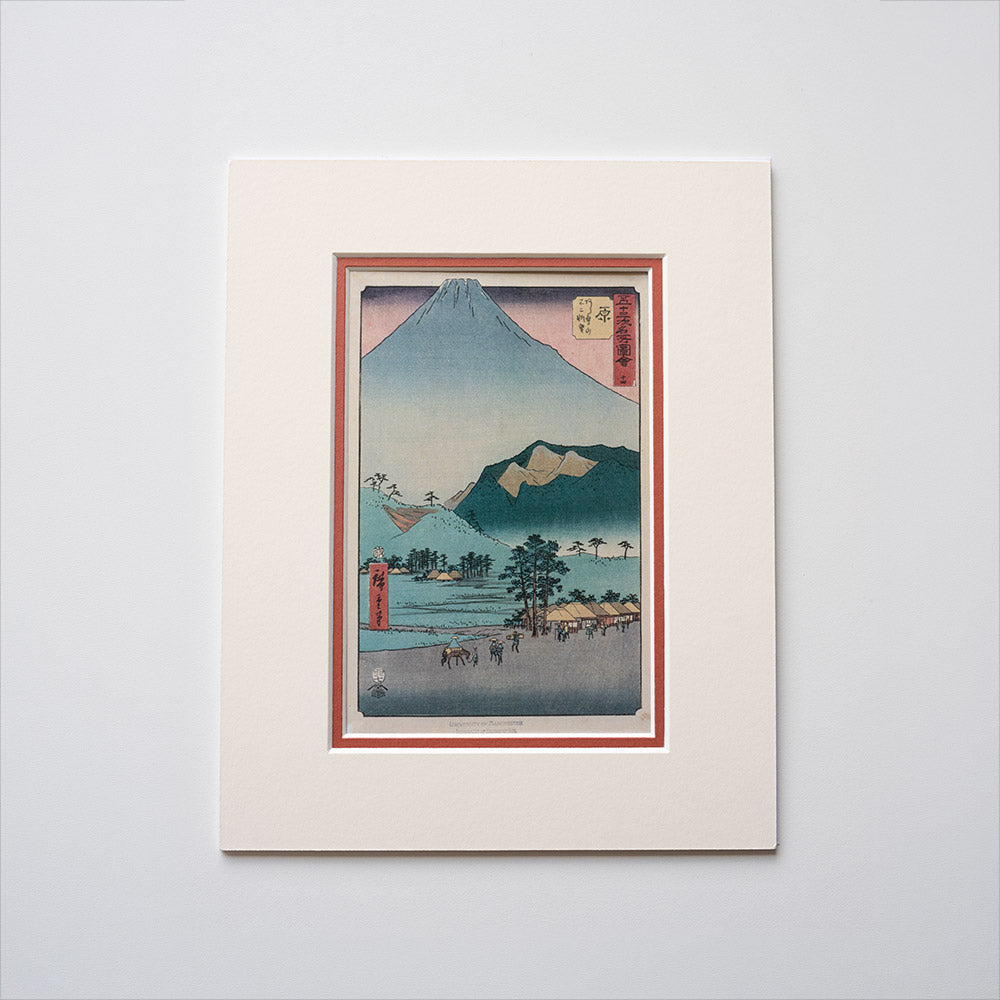 Mounted artwork of a mountain landscape with a red mount on a light grey background