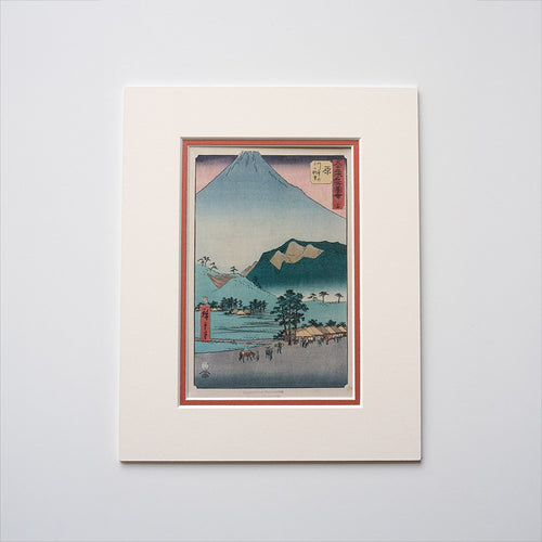 Mounted artwork of a mountain landscape with a red mount on a light grey background