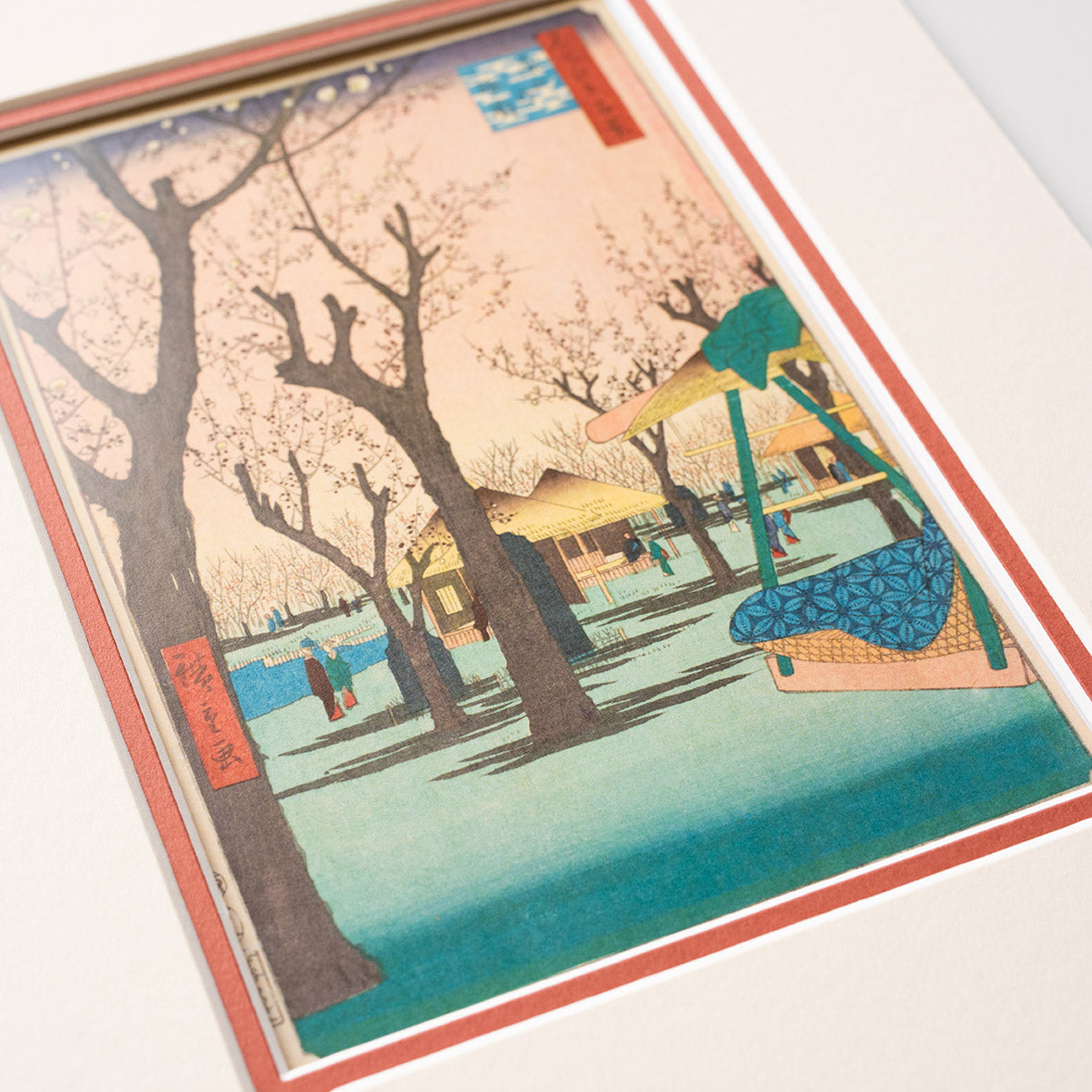 Cropped detail of mounted artwork of a cherry blossom tree scene on a light grey background