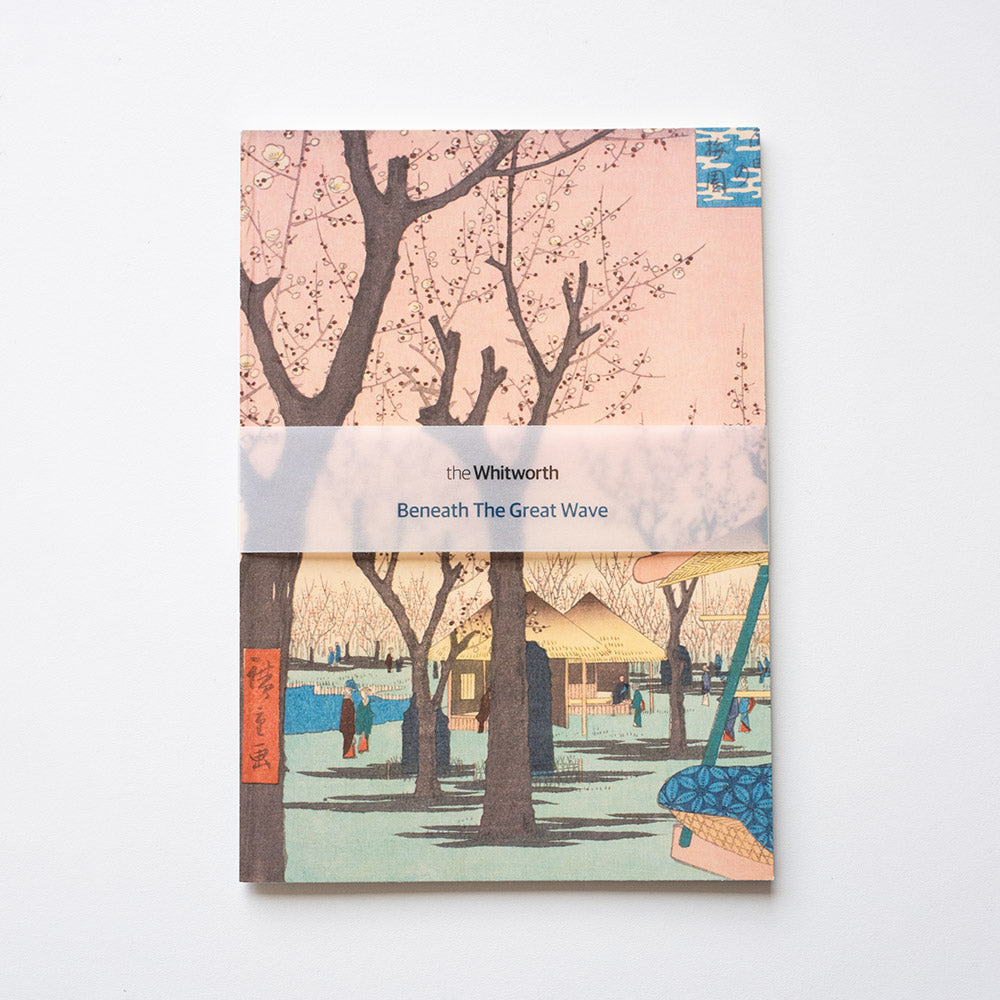 Notebook cover with cherry blossom trees and a scene of people by a river, featuring 'the Whitworth' branding.