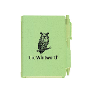 Green notebook and pen against white background. Notebook has an illustration of an owl and the Whitworth logo.