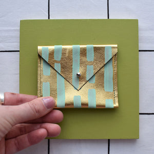 Gold metallic rectangular card pouch with hand painted design.