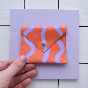 Orange rectangular card pouch with hand painted design.