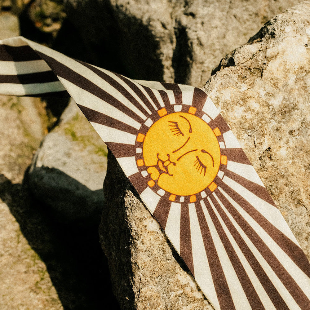 Striped scarf with sun design on a stone surface