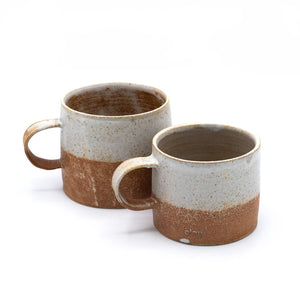 A pair of rusted colour two-tone mugs placed side-by-side in front of a white background