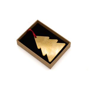 Brass tree-shaped decoration photographed in a cardboard box, laid flat, white background