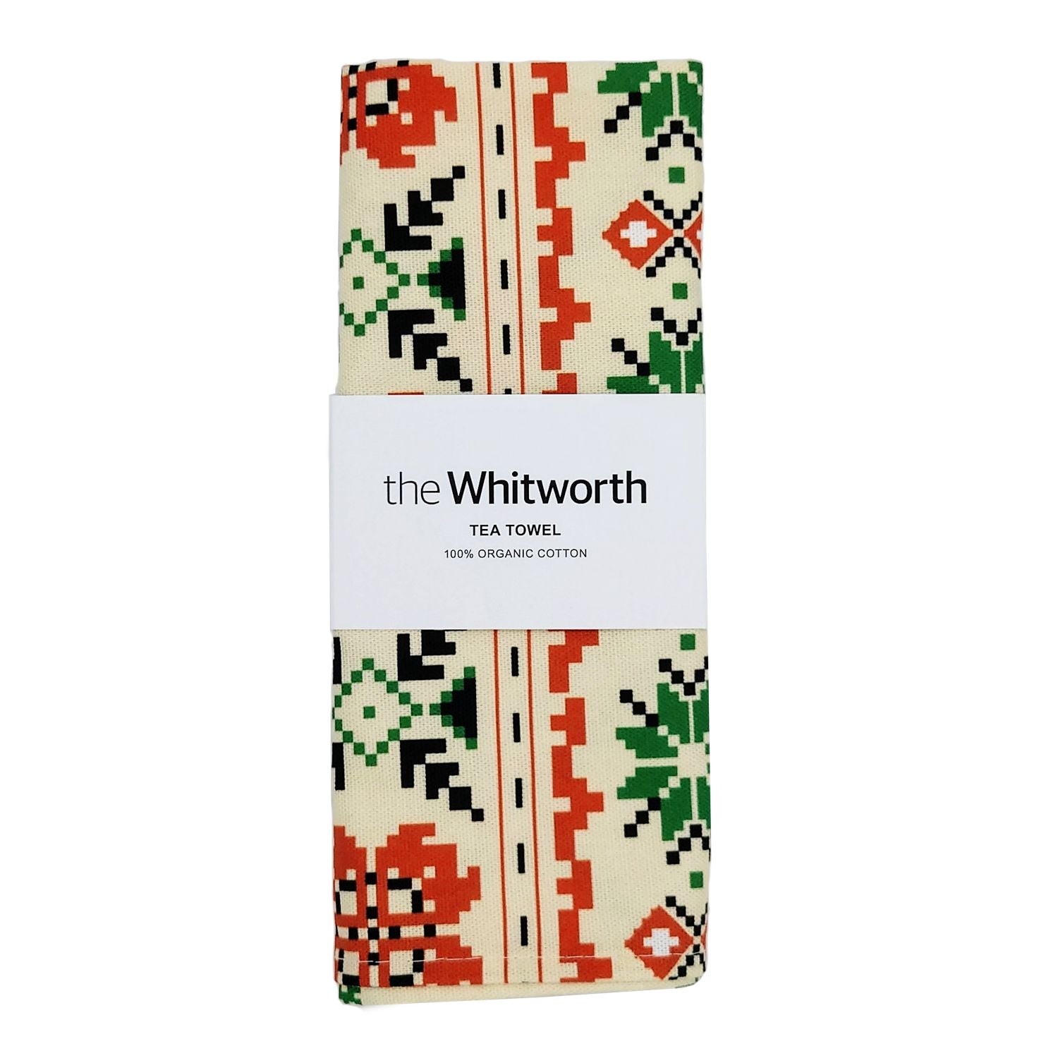 Folded tea towel with a white belly band around the middle. Black text on belly band: The Whitworth, Tea towel, 100% organic cotton. The tea towel has a beige background and green and orange floral and geometric patterning.