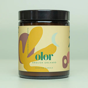 Candle in Jar with Olor yellow branding. Green background.
