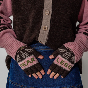 Person wearing pink and black gloves with 'FEAR' and 'LEES' text, holding a brown bag.