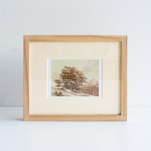 Framed artwork of a landscape with a tree on a white background