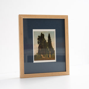 Framed artwork with a blue mount and wooden frame on a white background