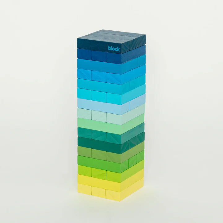 A tall tower of colourful wooden blocks stacked on top of each other. The blocks are in shades of blue, green, and yellow. The word "block" is written on the top block.