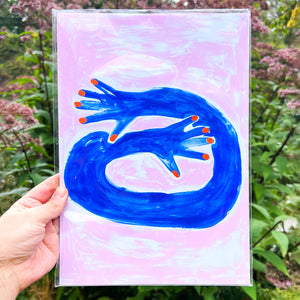 A person holding a risograph print against a garden backdrop. The print has an illustrated feel. The background is pink and there's an illustration of a arm hugging.