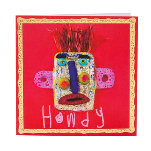 A brightly colored greetings card featuring a mask made by Arthouse Unlimited artists, of a playful, cartoon-like face with exaggerated features. The background is a red, and the card is outlined with a gold border. The text "HOWDY" is written below the face in a playful font.