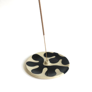 Ceramic insence burner with black and white seaweed pattern. White background.
