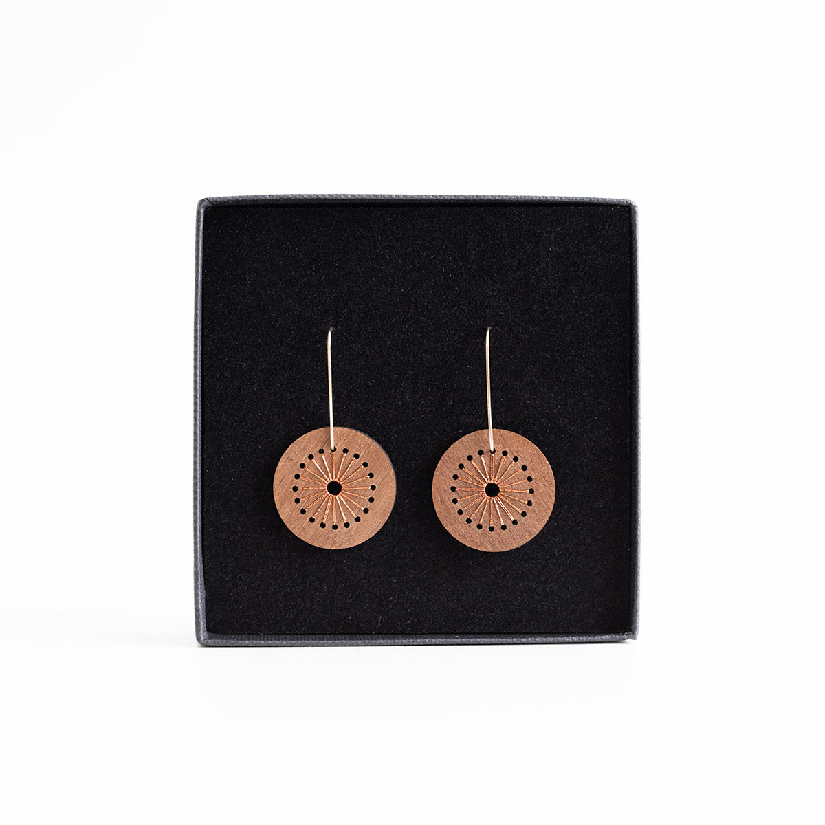 Pair of round earrings on a black display card