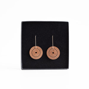 Pair of round earrings on a black display card