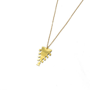 Brass pendant on a gold chain photographed against a white background. The pendant is a triangular shape.