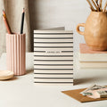 Striped birthday card on a desk with stationery items