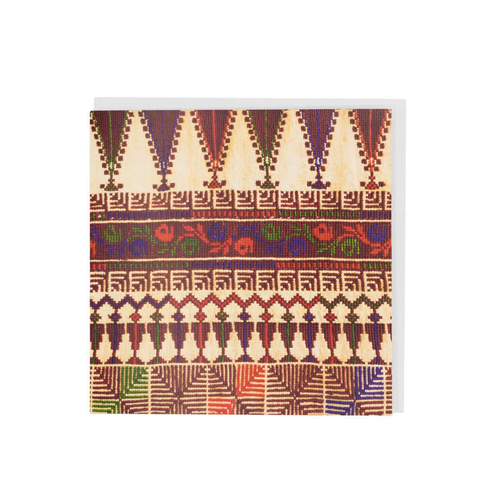 A square greetings card with white envelope. Greetings card features a close up photograph of a beige, brown and red embroidered dress.