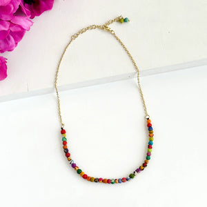 A colourful beaded necklace with a gold chain.