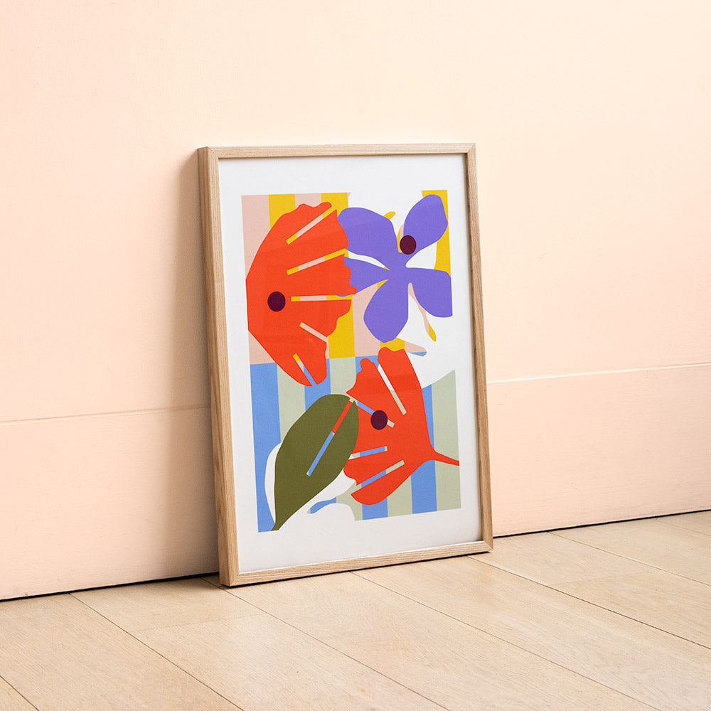 Print of digital illustration by Kate Moorhouse of colourful flowers - placed in an ash frame leant against a peach wall