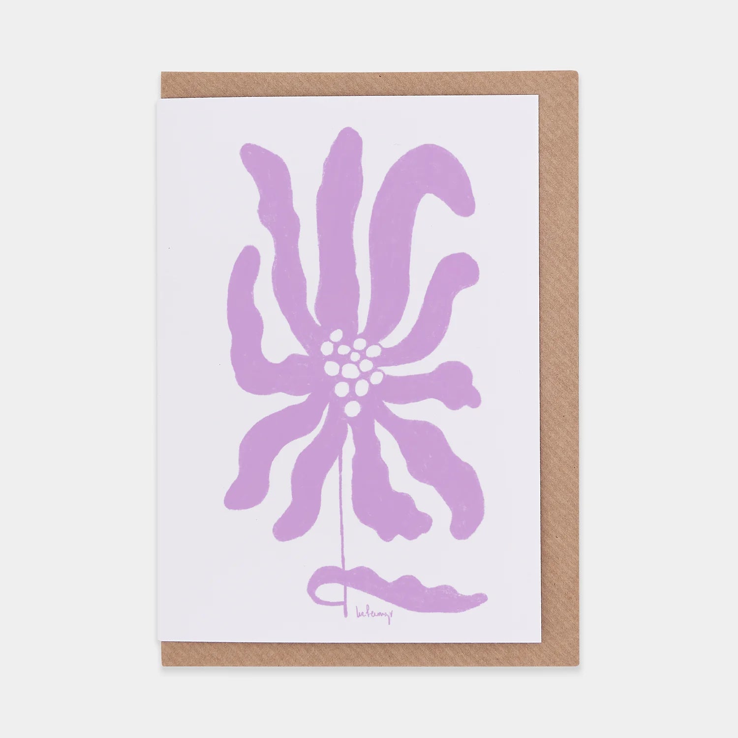 Greetings card featuring abstract purple flower. White background and brown envelope.
