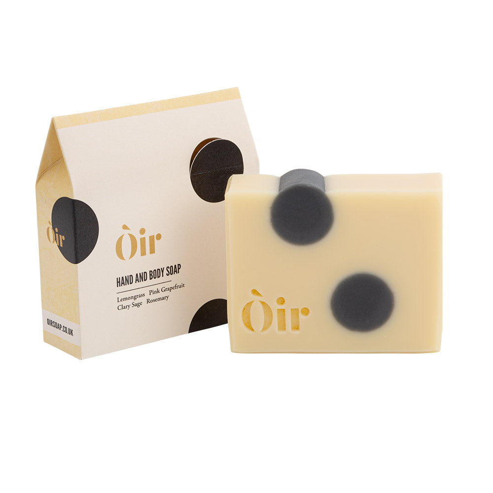 The image shows packaging for hand and body soap. It has a cream and black circles design.  To the right is the soap itself which seems to match the packaging design.