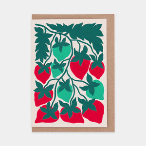 A greetings card featuring a bold and colourful illustration of strawberries. Brown envelope placed inside.