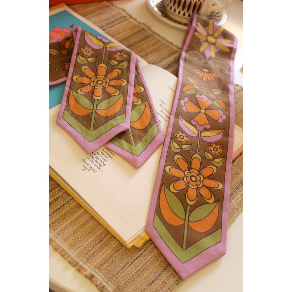 Floral scarves on an open book with a woven surface background