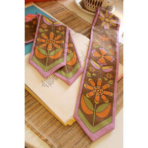 Floral scarves on an open book with a woven surface background