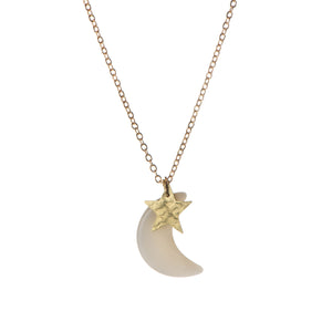 A gold necklace with a crescent moon pendant and a smaller star pendant attached to it. The moon pendant is white, while the star pendant is gold.