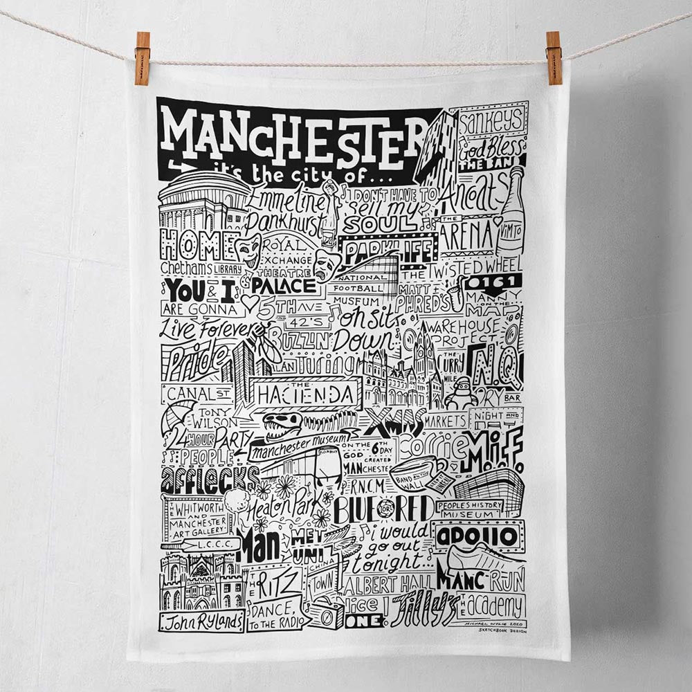 Tea towel featuring black and white illustrations of Manchester Landmarks.