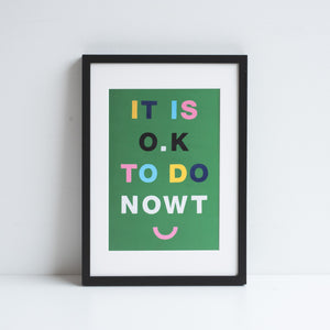 Artwork by Mikesian studio in a black frame, rested against a white wall. Green background with colourful typography